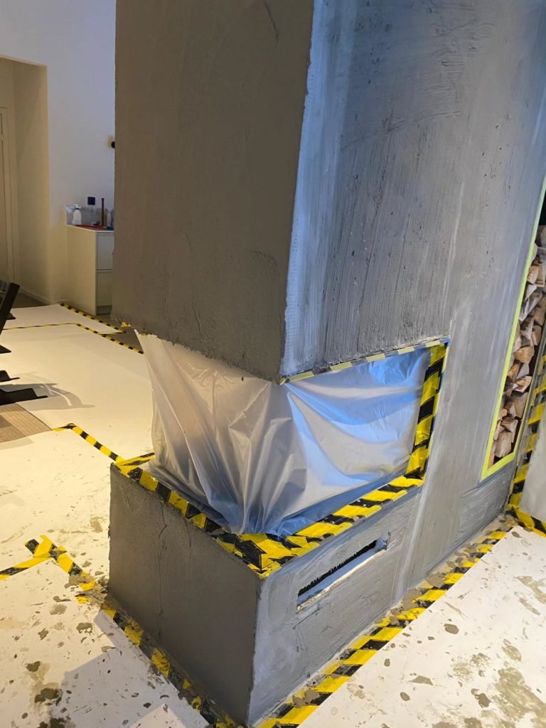 Platsbyggd kamin med integrerad vedförvaring.