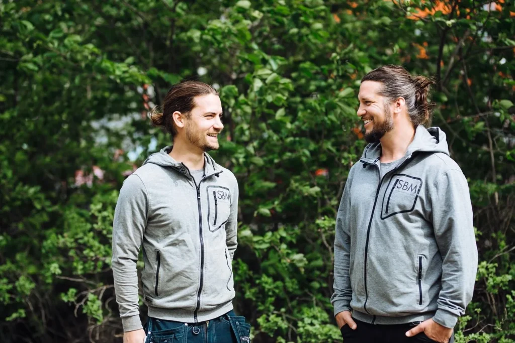 Två glada personer ler mot varandra. 
