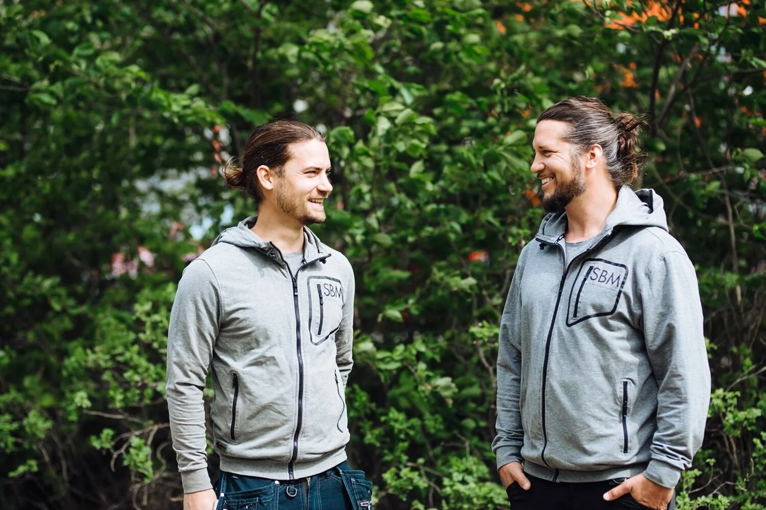 Två glada personer ler mot varandra.