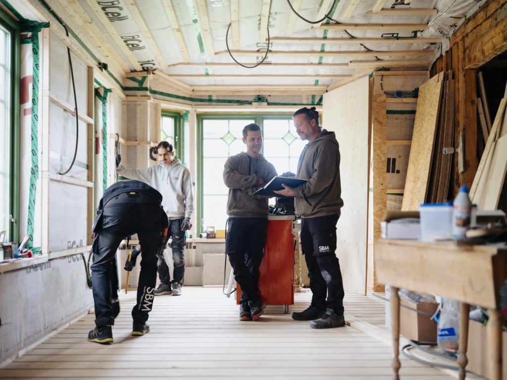4 personer står och planerar ett byggnationsprojekt