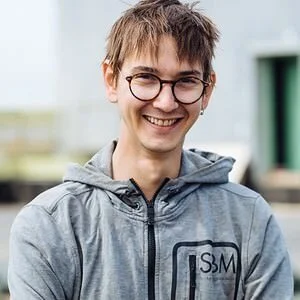 Kristoffer Eriksson ler generat mot kameran med glasögon