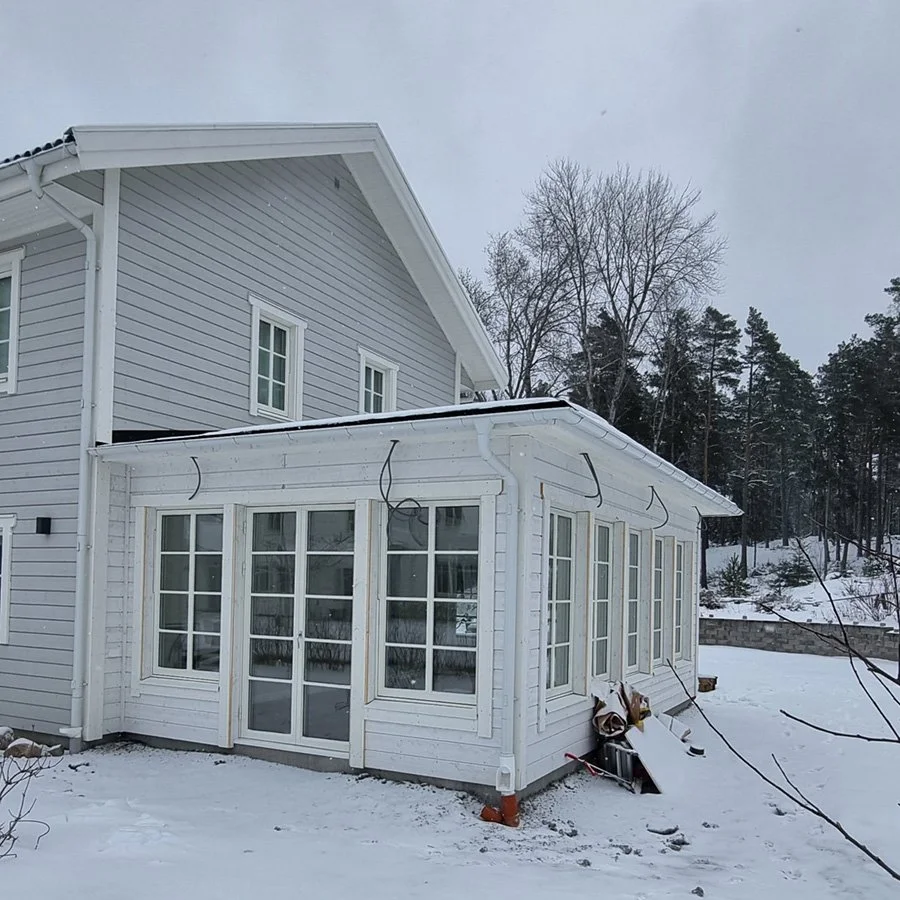 Ett vitt utehus undervintern med snö påö.